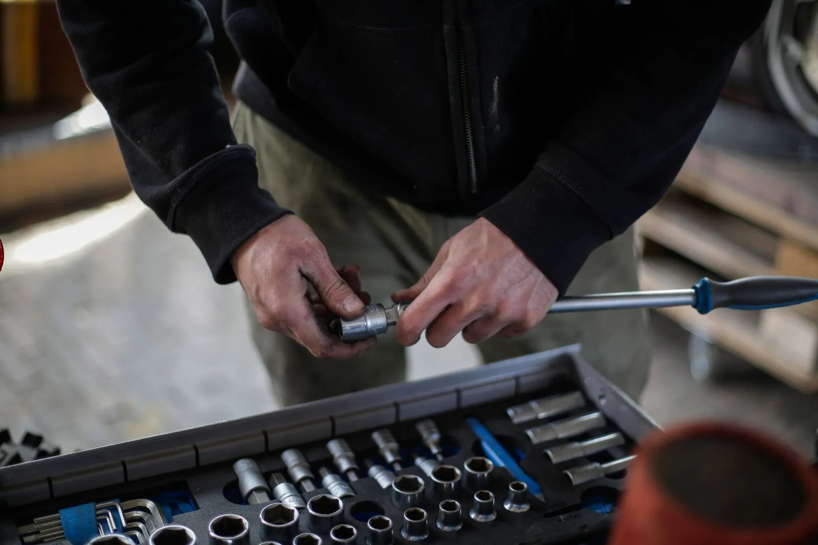Mechanic fitting a socket onto a ratchet over a tool tray